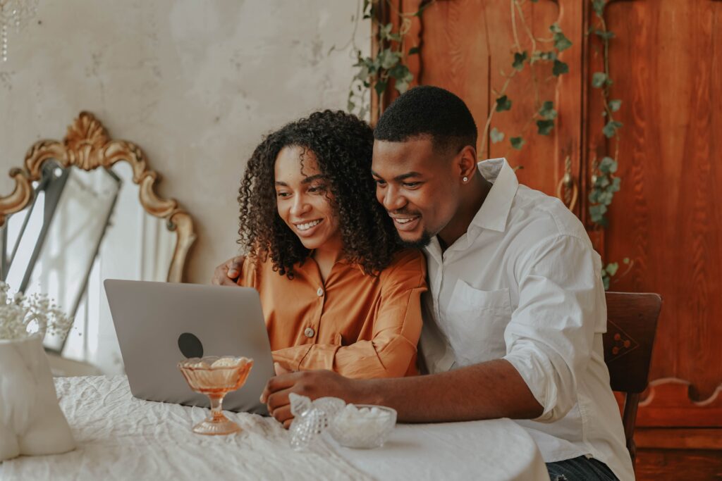 Engaged bride researching wedding vendors using AI search for wedding marketing on a laptop at a sunlit, styled planning desk