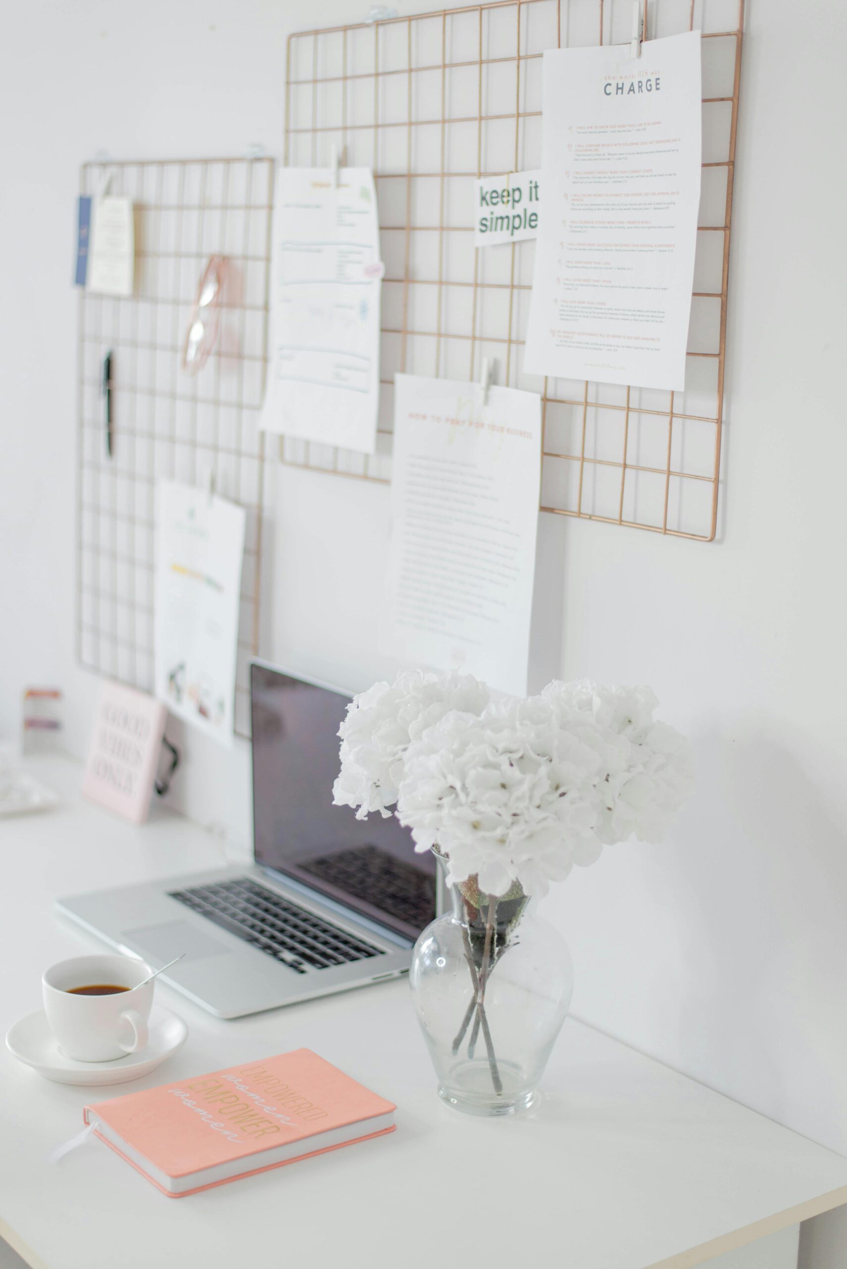 Wedding professional planning a Pinterest content strategy on a laptop showing a board of bridal inspiration