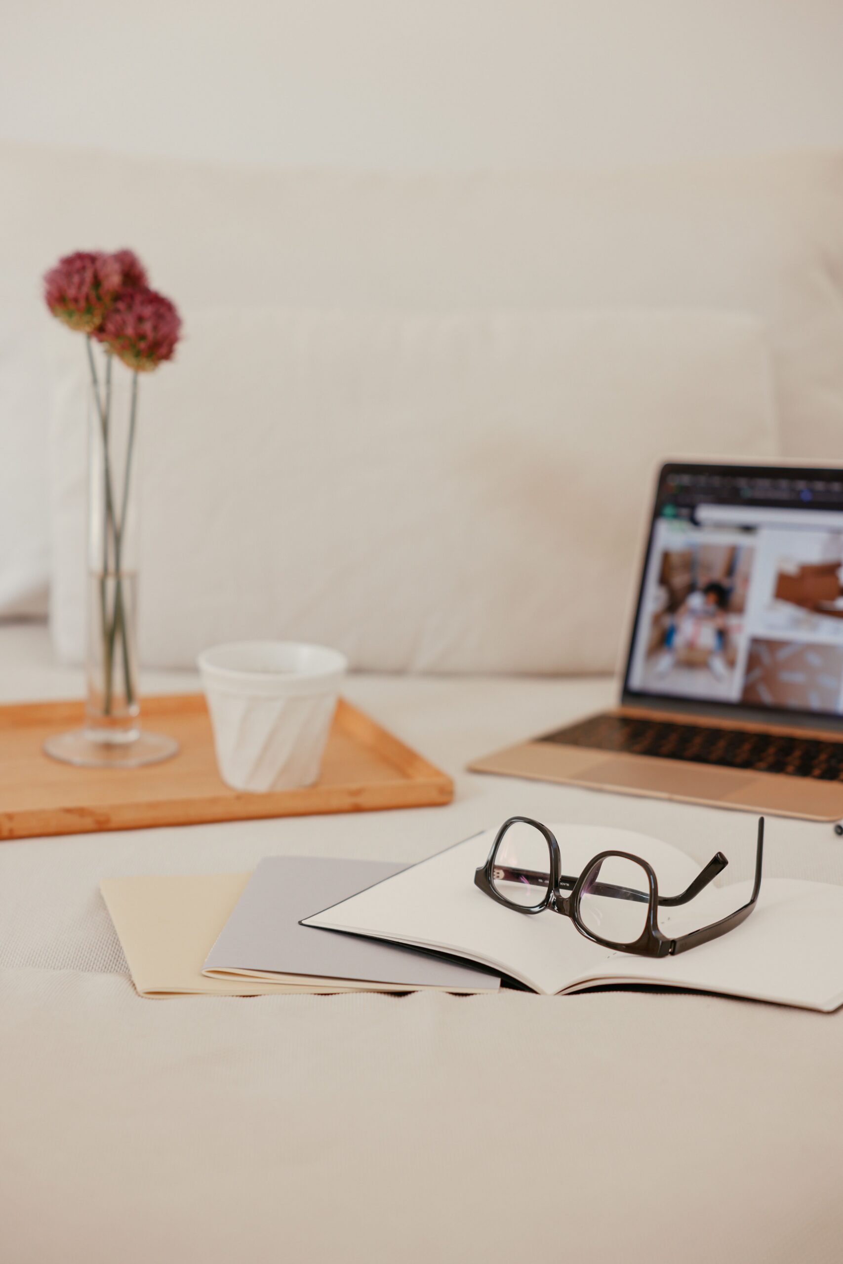 A wedding creative's quiet desk with a closed laptop and coffee, showing how evergreen visibility keeps working during off-season