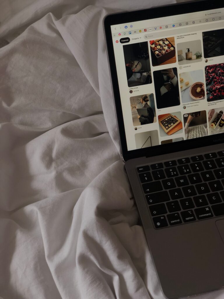 A wedding creative planning Pinterest marketing campaigns on a printed calendar next to a laptop and content notes