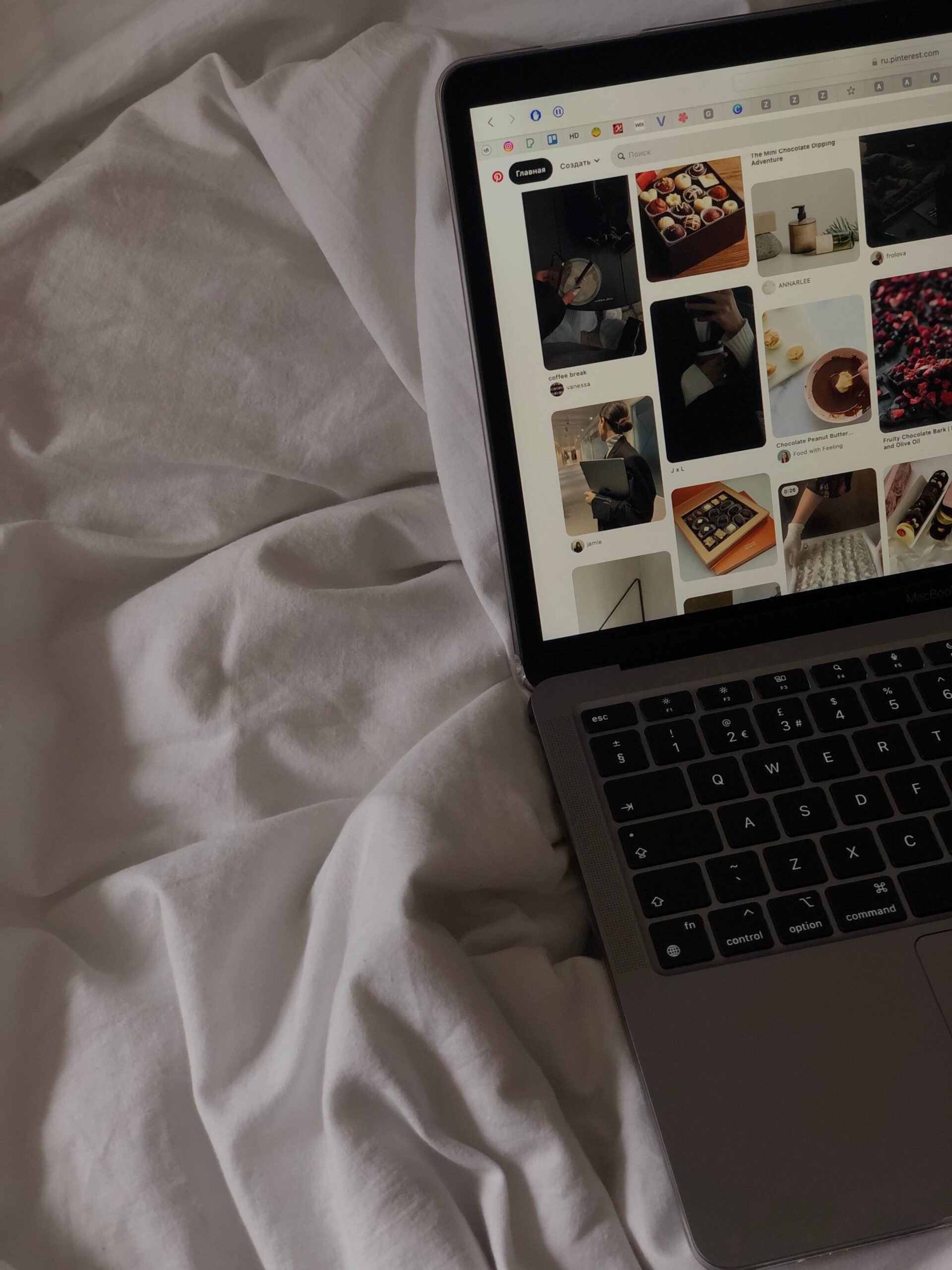 A wedding creative planning Pinterest marketing campaigns on a printed calendar next to a laptop and content notes